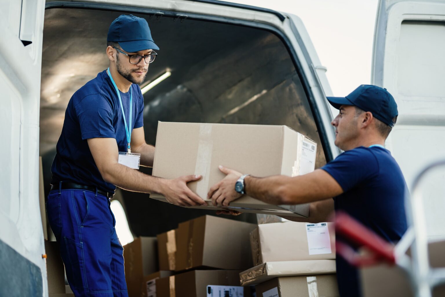 delivery-men-loading-carboard-boxes-van-while-getting-ready-shipment-2-1536x1024